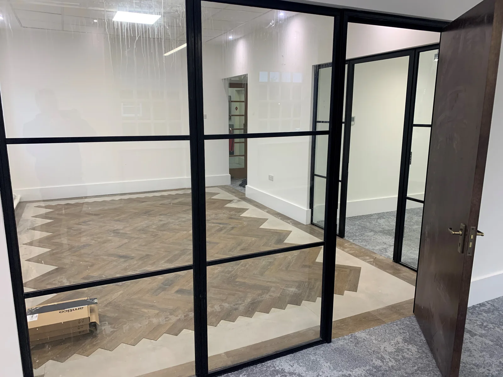 Heritage-framed internal glass partition separating rooms while retaining a view through