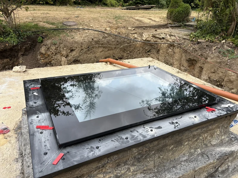 Walk-on skylight being positioned into prepared opening