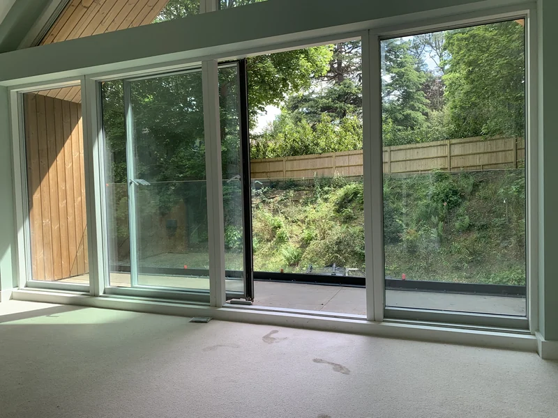 Interior view from the bedroom — large floor-to-ceiling glazing and glass balustrade at Henley-on-Thames timber home
