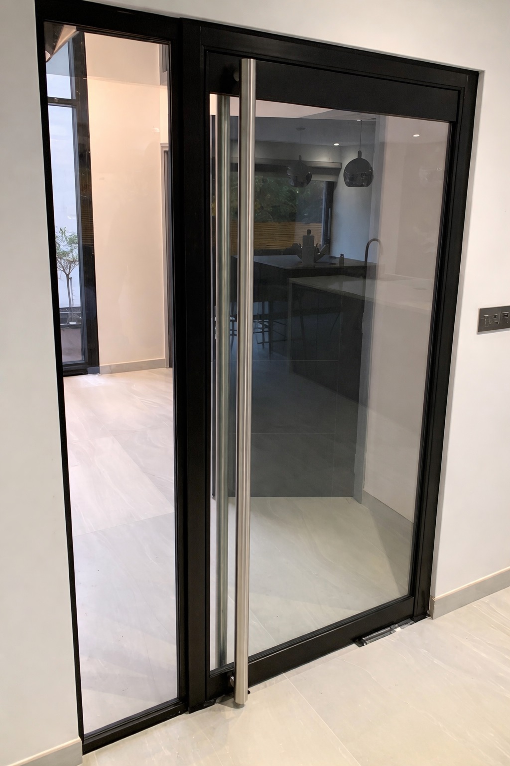 Black-framed glazed door and side panel in a bright home interior