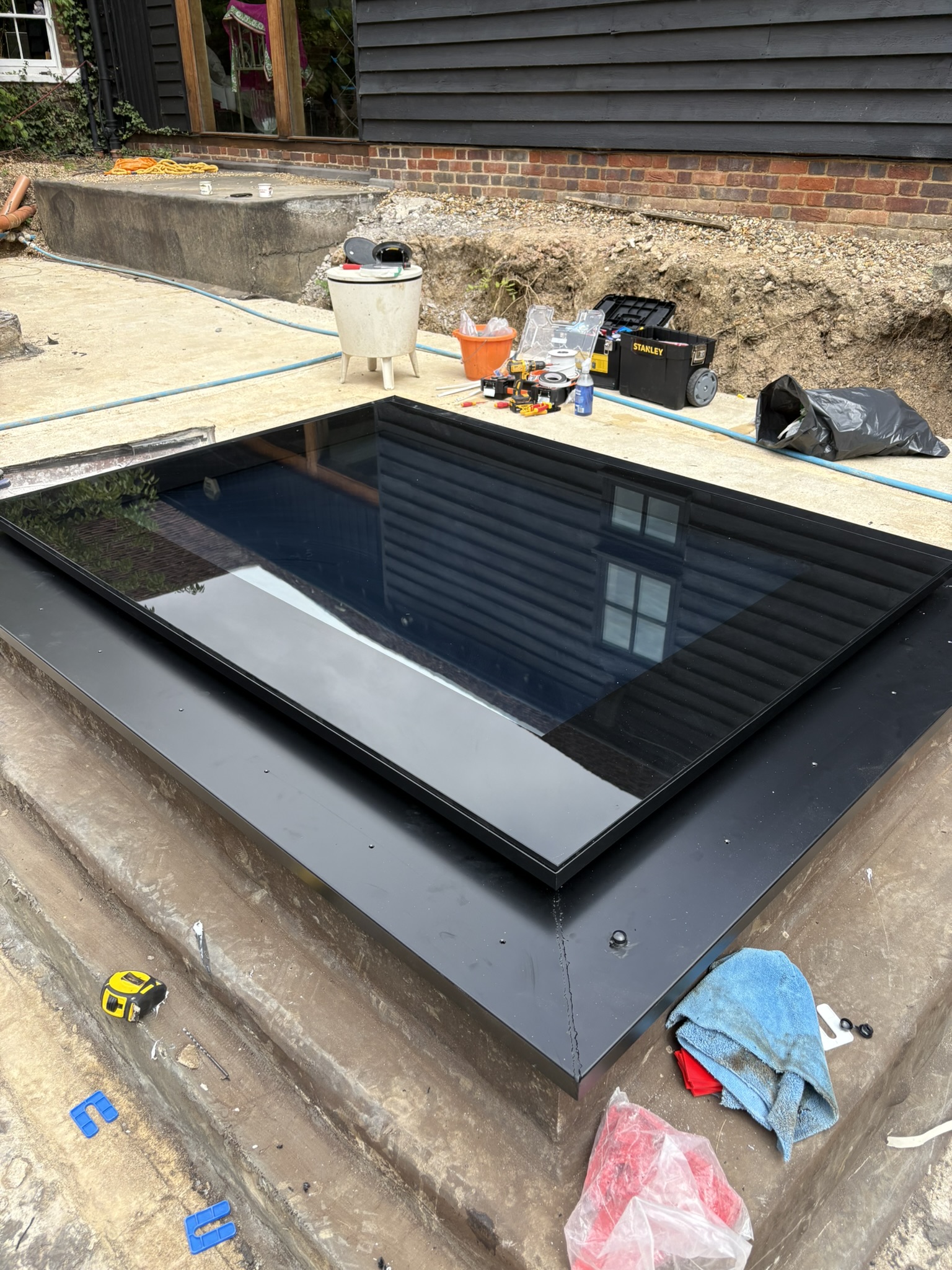 Bespoke walk-on skylight unit installed — black aluminium frame with tinted switchable glass