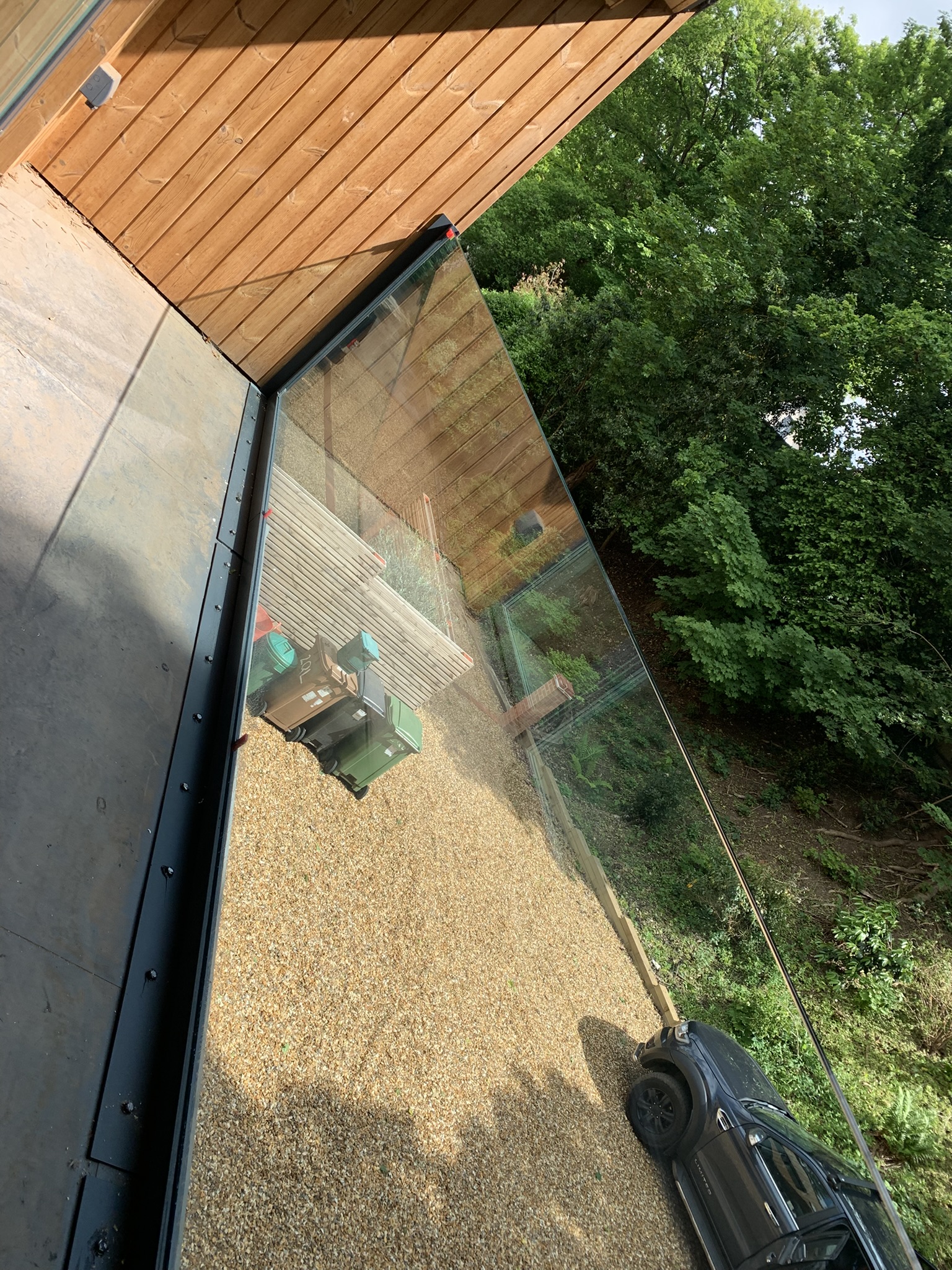 Looking down through the glass balustrade — clear view to gravel drive and grounds below